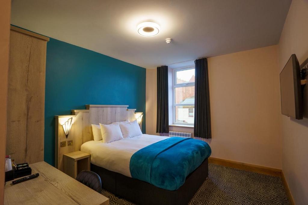 a hotel room with a bed and a window at The Bath Rooms in Morecambe