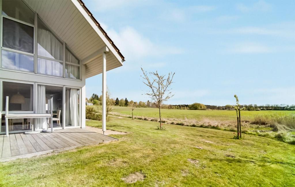 a house with a wooden deck next to a field at Nice Home In Röbel With Sauna in Röbel