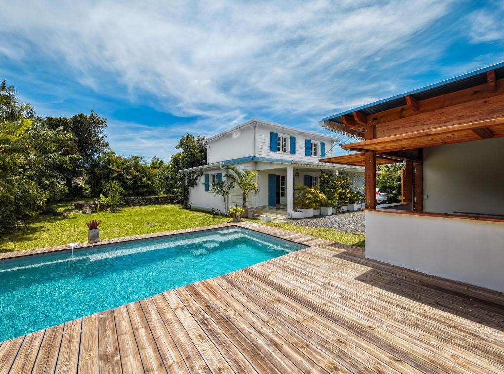 a home with a swimming pool and a house at Villa kréoli avec picine privée et cuisine extérieur pour 8 personnes in Saint-André