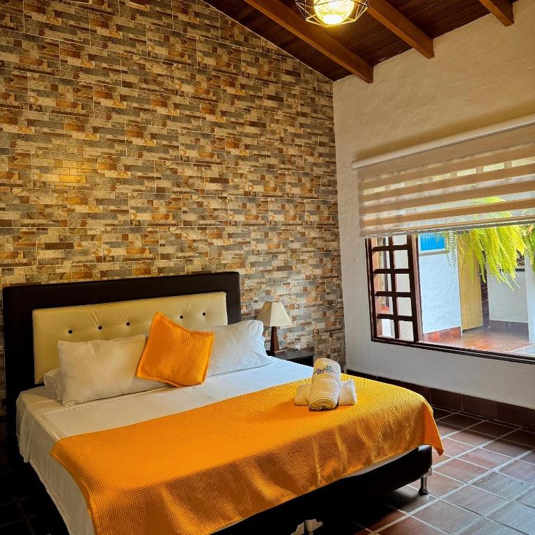 a bedroom with a bed and a brick wall at Hotel campestre los gabrieles in Rivera