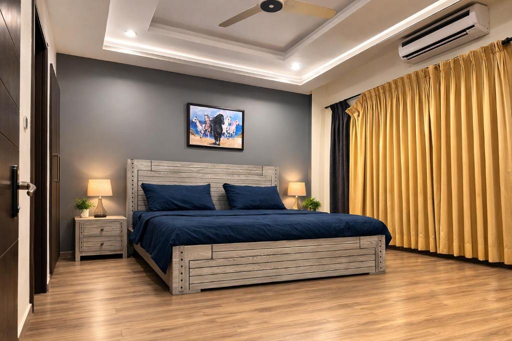 a bedroom with a bed with a blue comforter at Prime Stays Rezidor in Rawalpindi