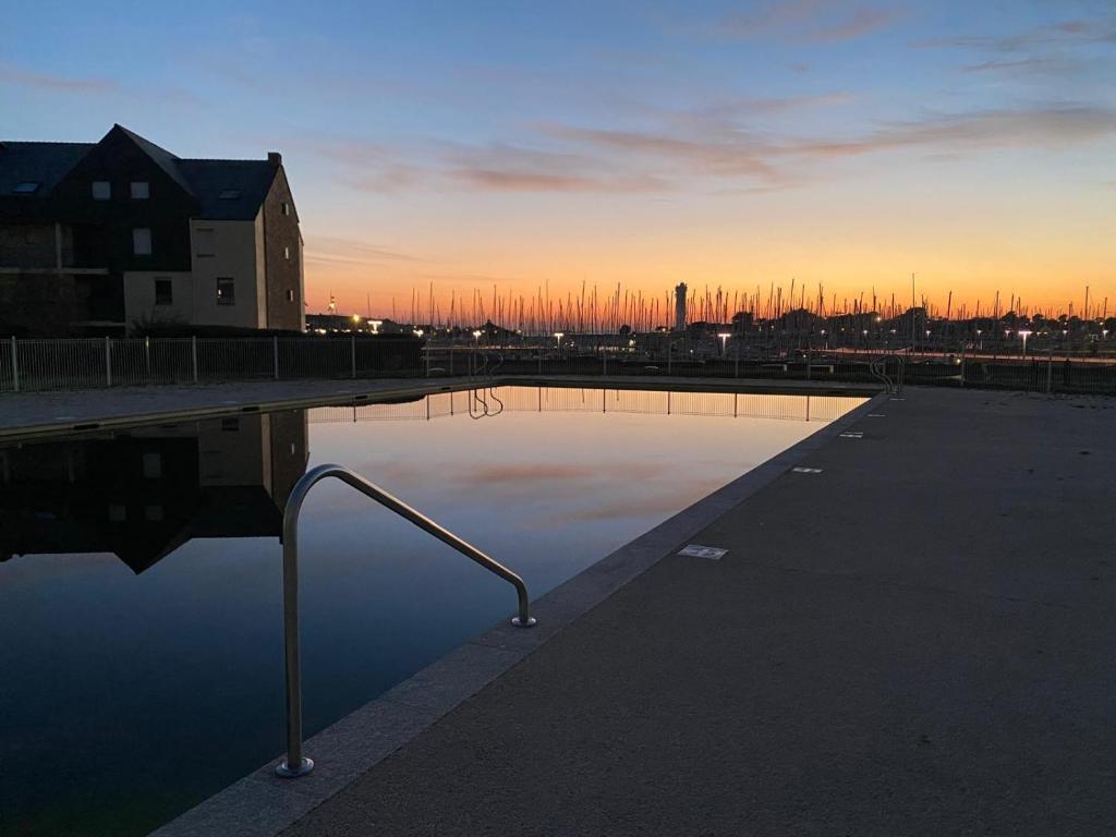 a parking lot with a pool of water at sunset at Escale au Port du Crouesty in Arzon