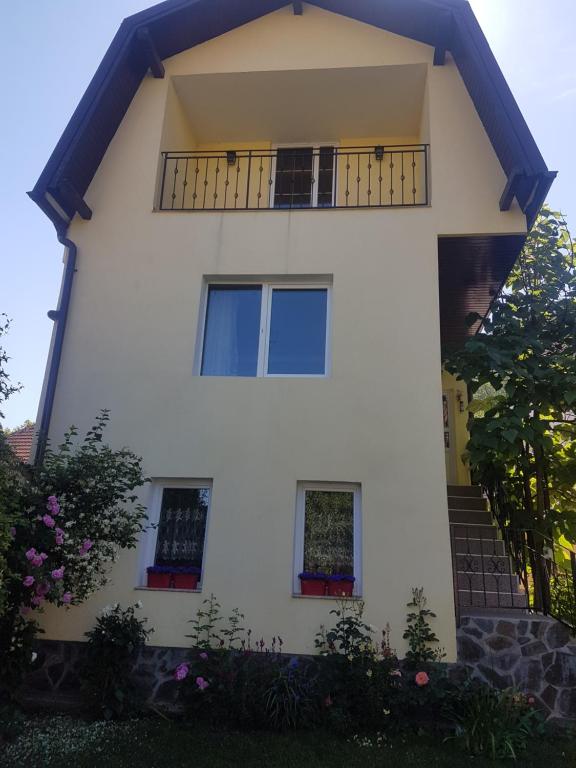 a white house with a balcony at Apartament Teilor in Râşnov