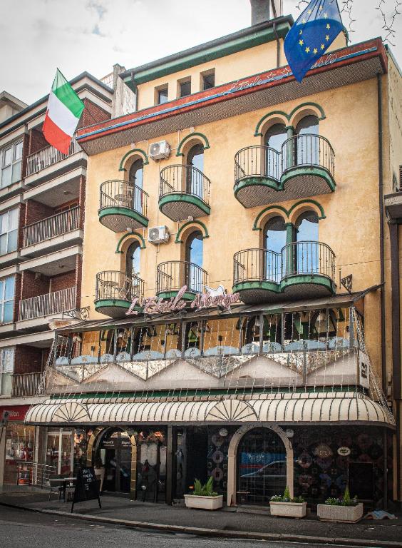 a large building with balconies and flags on it at Hotel l'etoile de la ville in Montecatini Terme