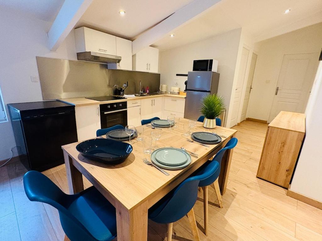 a kitchen with a wooden table and blue chairs at L'Emile Zola l 2 Chambres l Hypercentre in Castres
