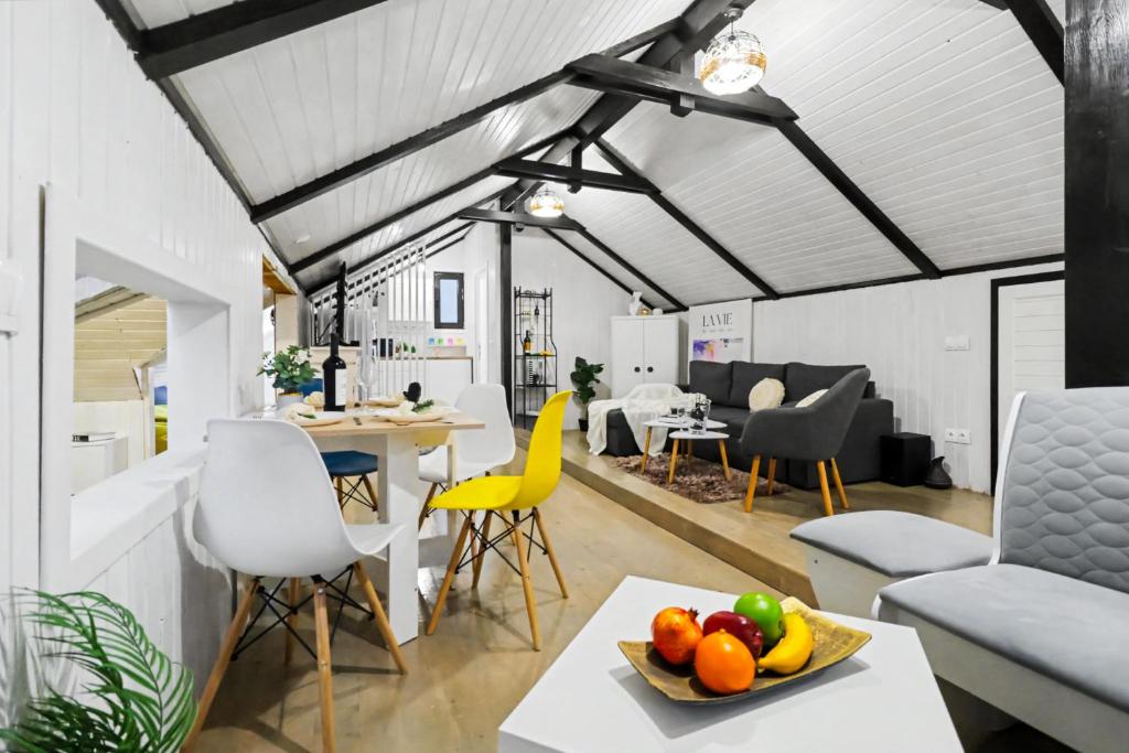 an open living room with a table and chairs at The HIDE - Loftette in Ploieşti