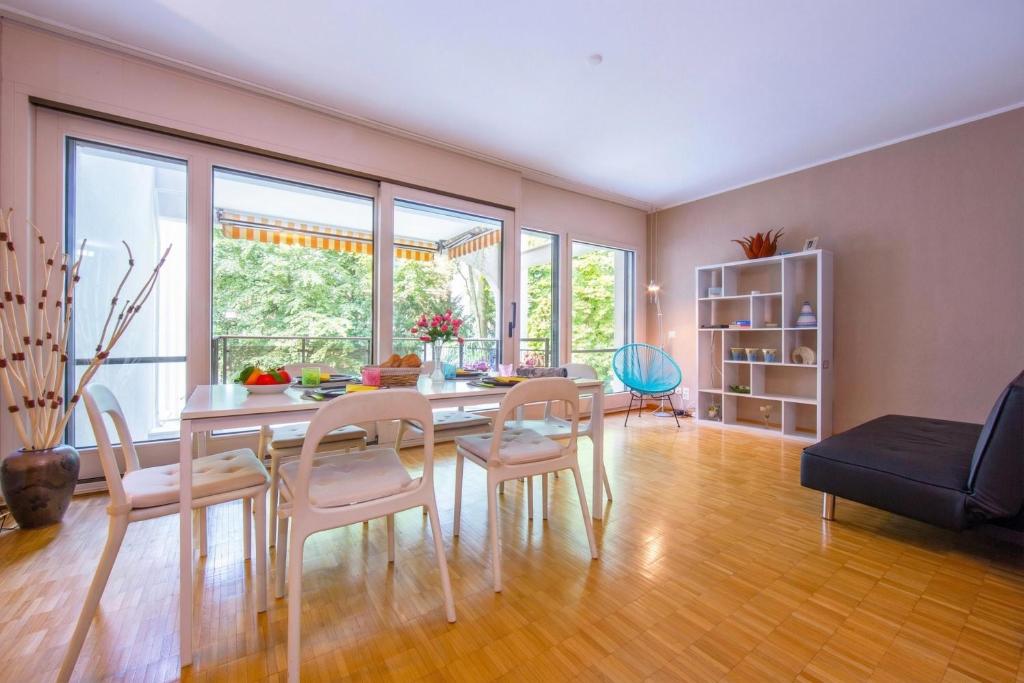 a living room with a dining room table and chairs at Maraini Elegante Apartment with Jacuzzi & Balcony - Happy Rentals in Lugano