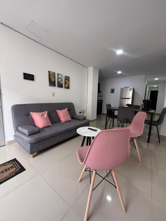 a living room with a couch and a pink chair at Moderno Apto central in Estación El Salto