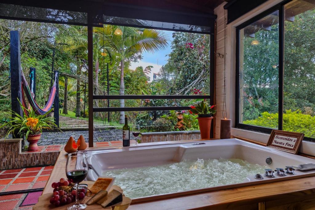a large bath tub in a room with a large window at Chalé de montaña con Jacuzzi in Guarne