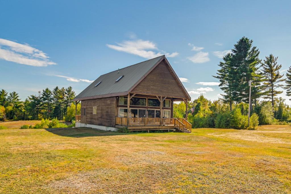 a large wooden cabin with a porch in a field at Mountain-View Deck! Cabin By Mt Abraham Trails in Kingfield