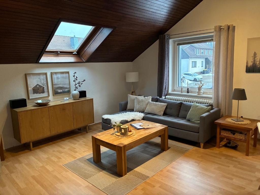 a living room with a couch and a table at Harz-Urlaub-Altenau - Hunde willkommen in Altenau