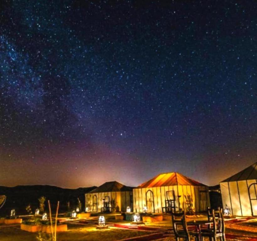 a building under a starry night sky with stars at Starry Nights Camp in Merzouga