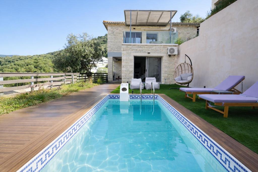 a villa with a swimming pool and a house at Saint Helen Villas in Parga