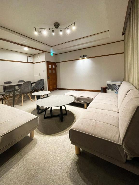 a room with two beds and a table in a room at 呼人2 Arun別邸 in Abashiri