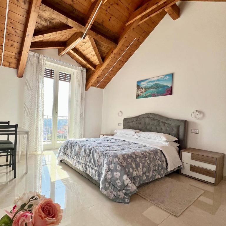 a bedroom with a bed and a large window at La Villa Carmelina in Agerola