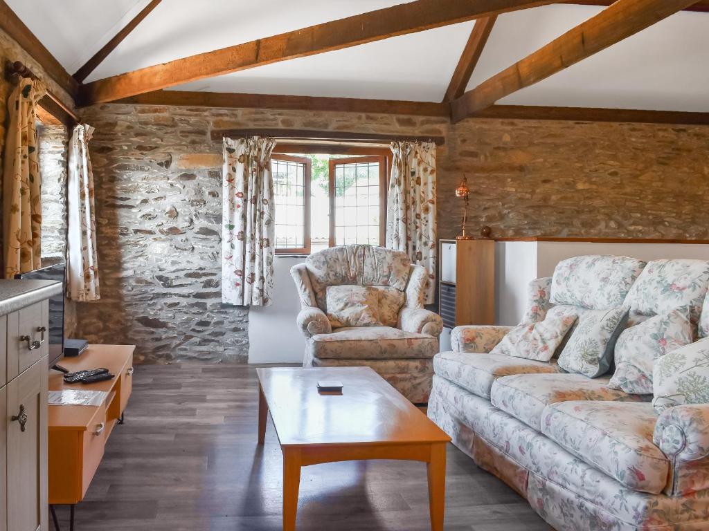 a living room with a couch and a table at The Hayloft - Uk50027 in Liskeard