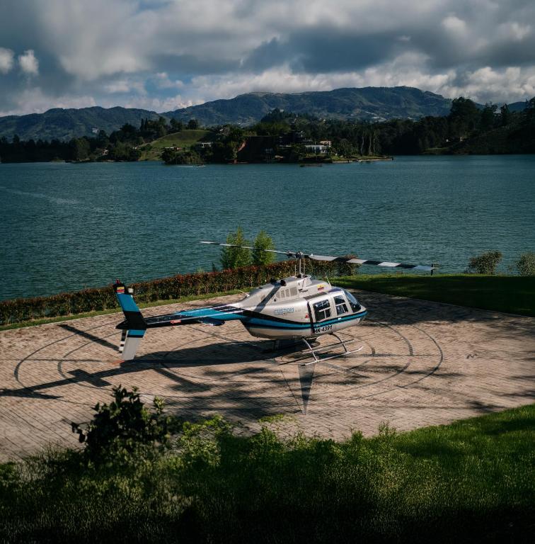 a small helicopter parked next to a body of water at Bliss Sanctuary Vista - Glamping and Club in Guatapé