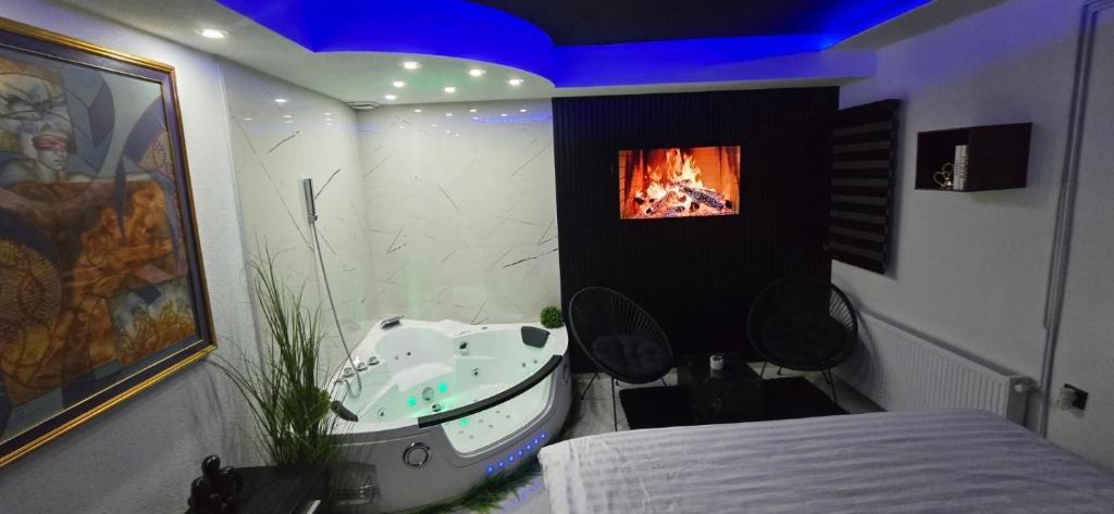 a bathroom with a tub and a sink with a fireplace at Tina apartman in Vranje