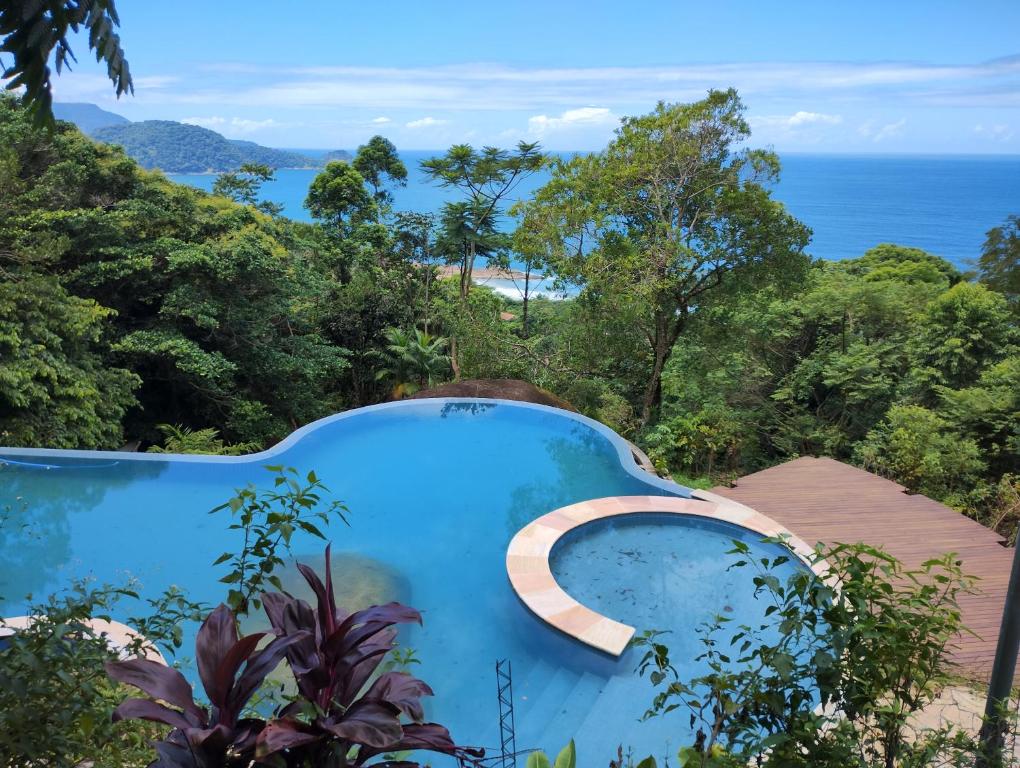 a blue pool with a view of the ocean at Pousada Samambaia in Paraty