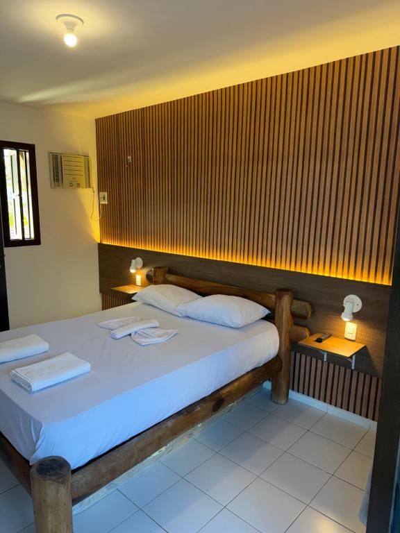 a bedroom with a bed with two towels on it at Mar Azul Flats com Piscina, Cozinha mais estacionamento em Ponta N in Natal