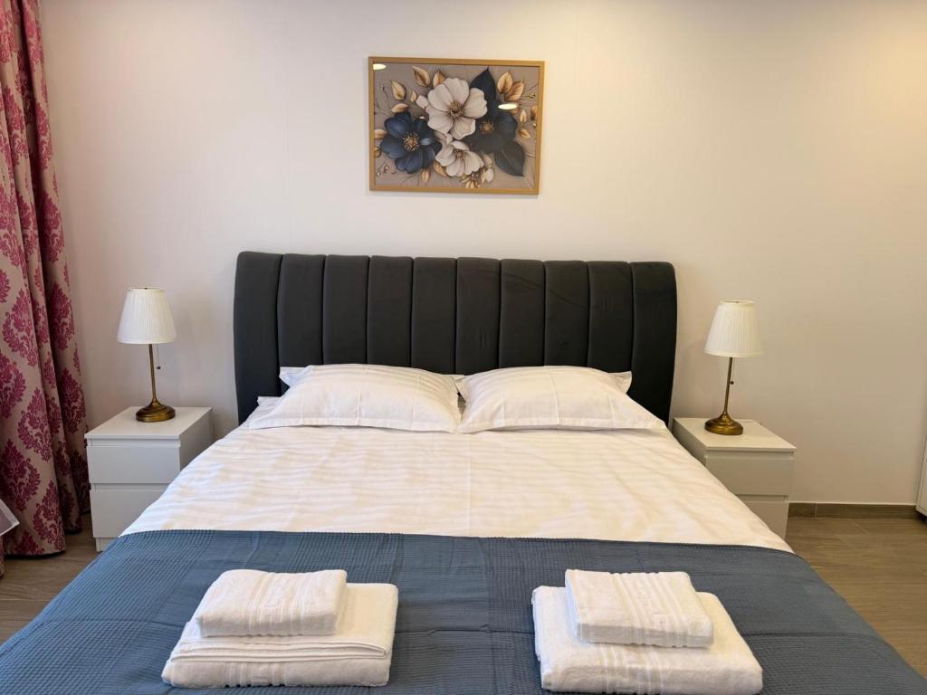 a bedroom with a large bed with two towels on it at Best4You Apartment Therme Airport in Baloteşti