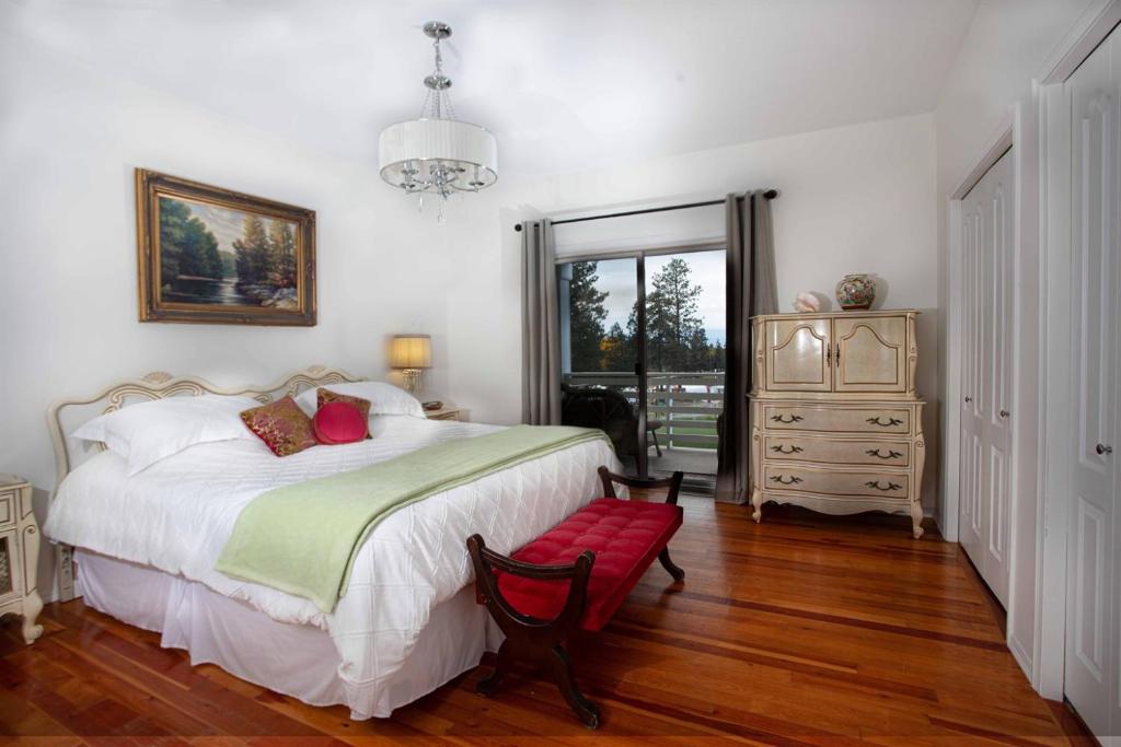 a bedroom with a large bed and a red bench at Pet Friendly Licensed Suite on Haskap Farm in Kelowna