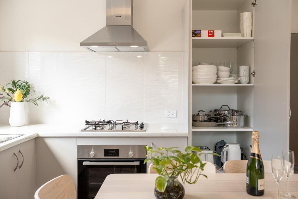 a kitchen with white cabinets and a stove top oven at Modern Family Home Near Fiona Stanley & Murdoch Uni in Perth