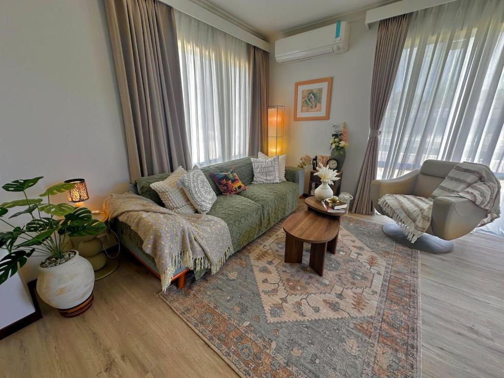 a living room with a green couch and a table at Ocean Breeze in Perth