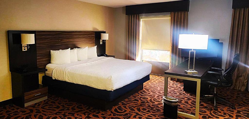 a hotel room with a large bed and a desk at Baymont by Wyndham Midland TX in Midland