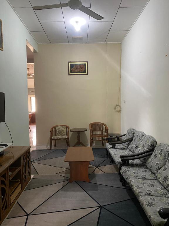 a living room with couches and chairs and a tv at Best Homestay in Kuala Rompin