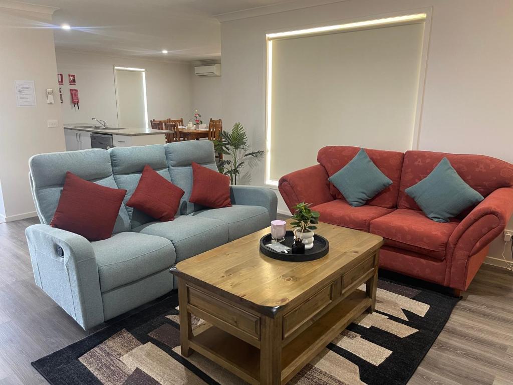 a living room with two couches and a coffee table at Accomodation at Lavington in Lavington