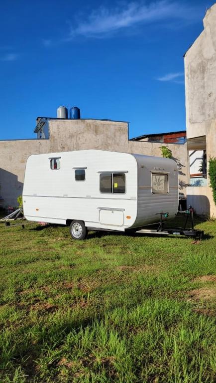 a white trailer parked in a grass field at Trailer cassa Rodante in Posadas