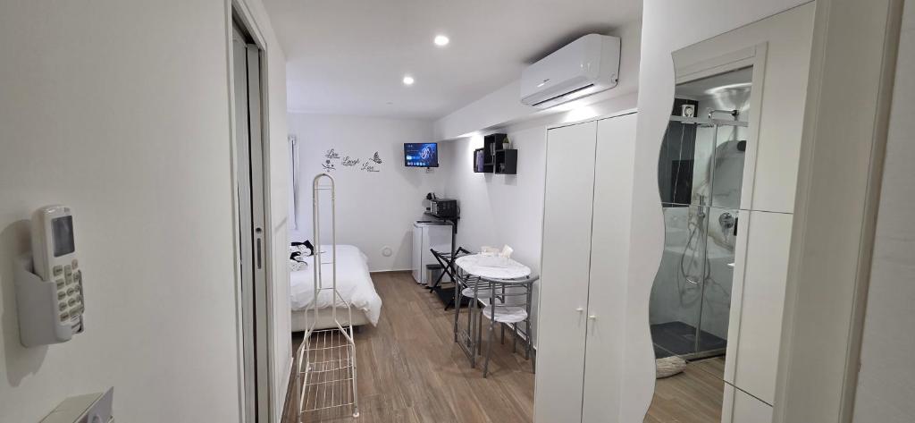 a room with a bathroom with a table and a shower at Black & White Rooms in Bari