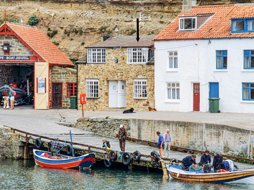 a group of people on boats at a dock at The Anchorage in Staithes