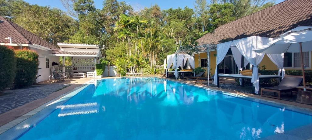 a large blue swimming pool next to a house at Loma Resort in Khao Lak