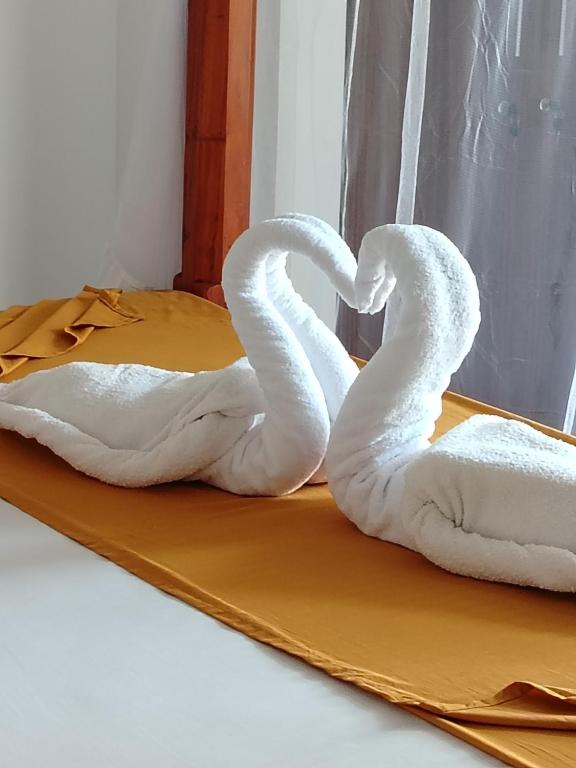 two swans shaped like hearts sitting on a bed at Villa Pabasara in Talpe