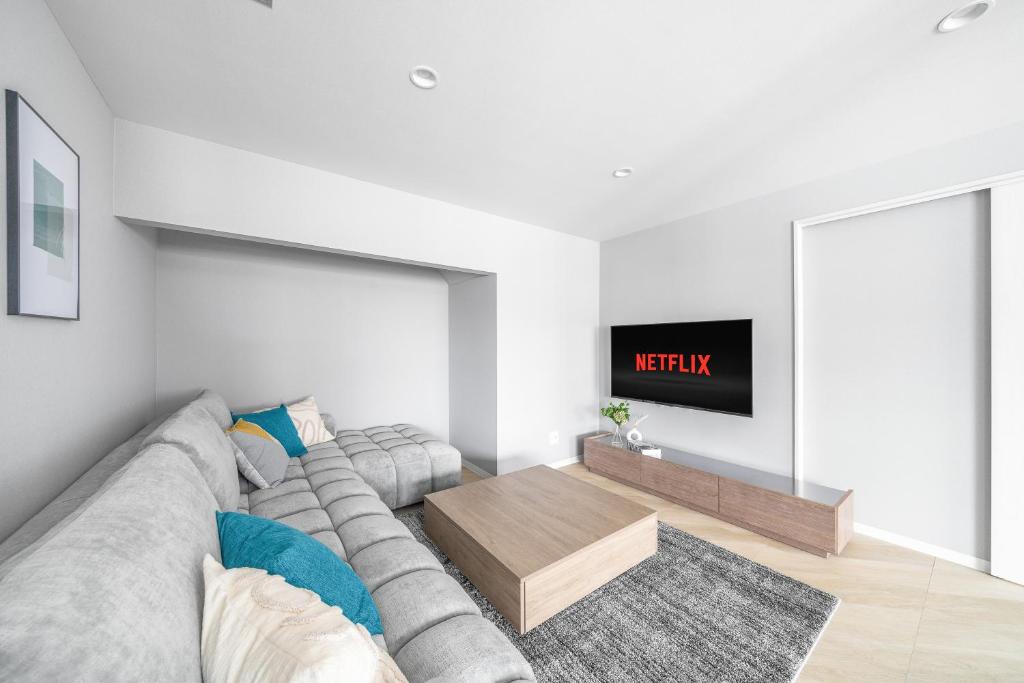 a living room with a couch and a tv at Villas Park Kamifurano in Kami-furano