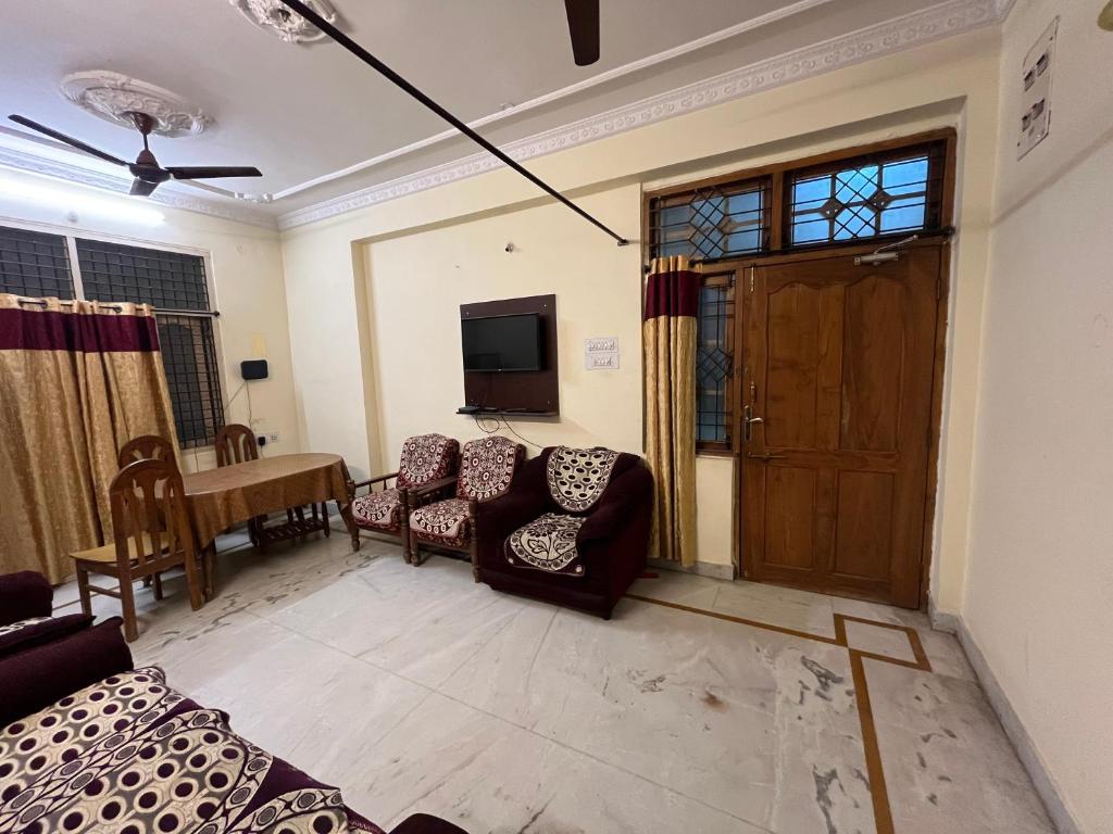a living room with a couch and chairs and a television at Aijaz Arcade in Hyderabad