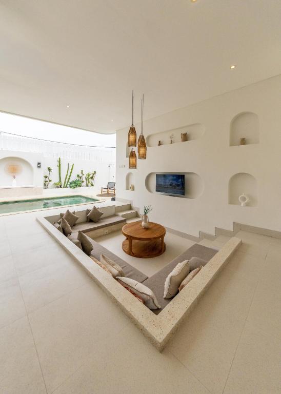 a living room with a couch and a table at Nirvana Canggu 2BR Near Berawa in Mantaak