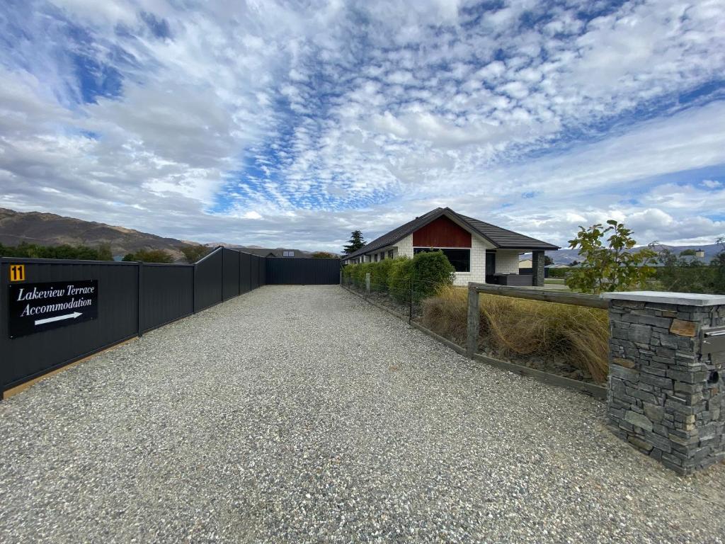 a driveway leading to a house with a fence at Lakeview Terrace Accommodation in Cromwell