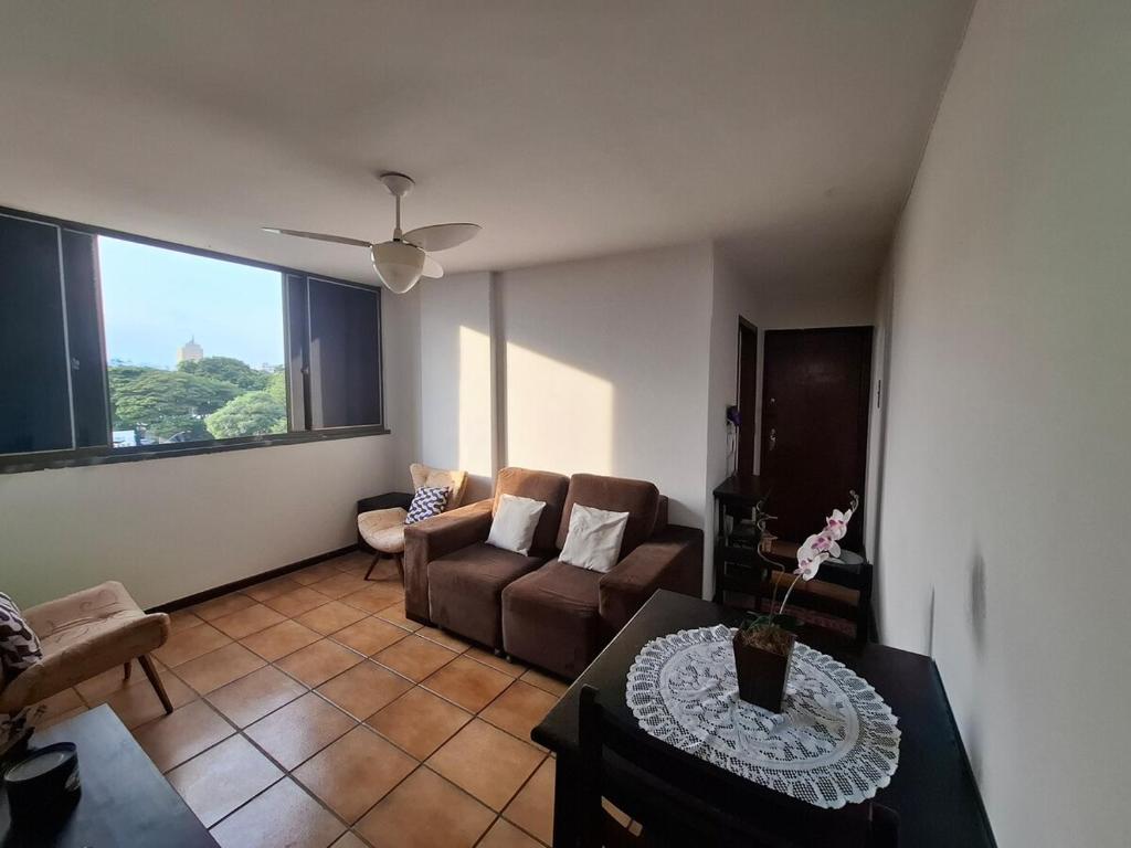 a living room with a couch and a table at Apartmento Moto GP in Goiânia