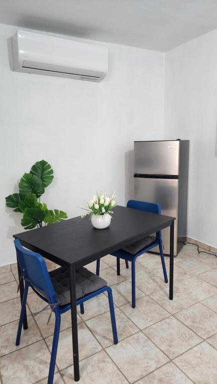 a black table and two blue chairs in a room at JG Residences in San Juan