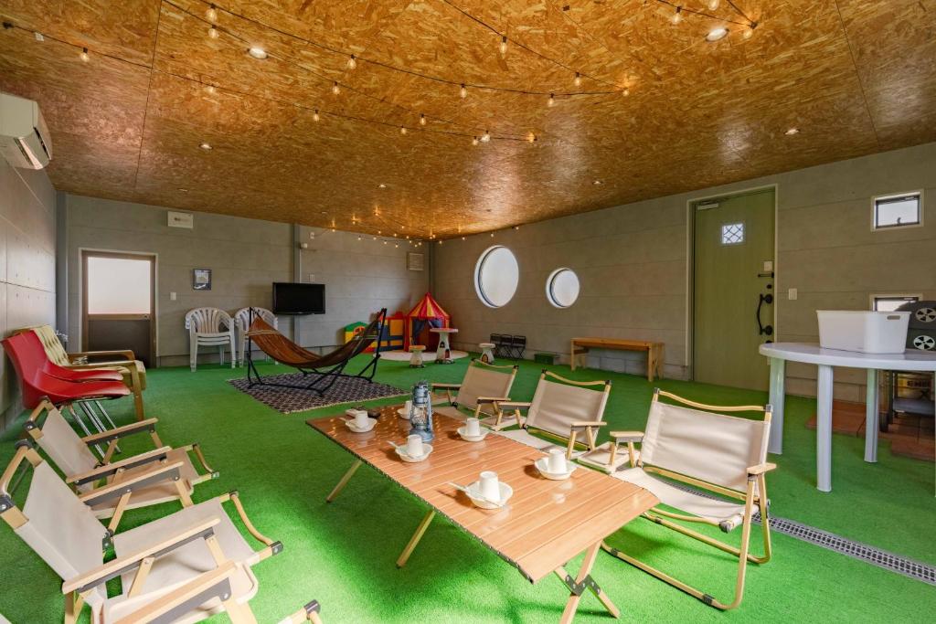 a room with chairs and a wooden table and a table and a table at NODOKA Awajishima in Minamiawaji