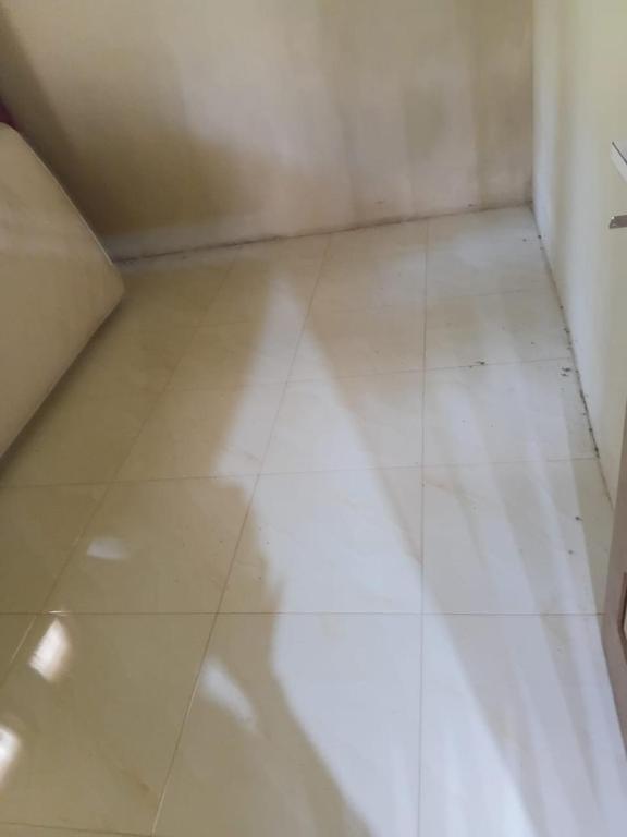 an empty room with a white tiled floor at Musni Guest House in Tarusan