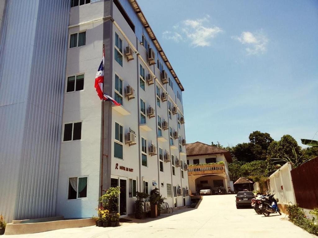 a tall white building with an american flag on it at Hotel De Ratt in Phuket