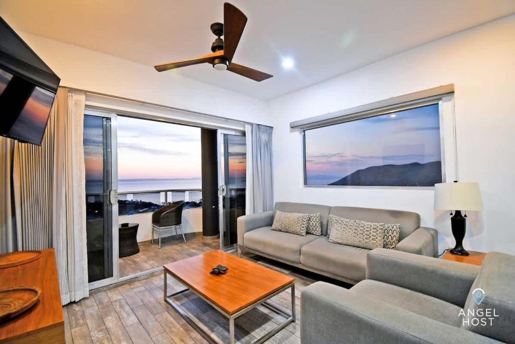 a living room with a couch and a large window at Gated Community Oceanview Condo Pool & Gym in La Paz