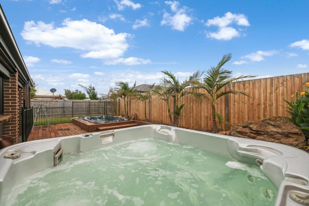 a hot tub in a backyard with a fence at Paradise Point Cowes in Cowes