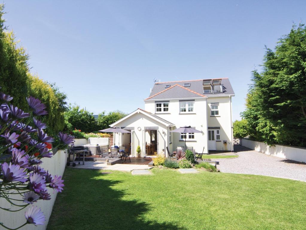 a white house with a yard with purple flowers at Four Seasons - Hw7432 in Tal-gareg