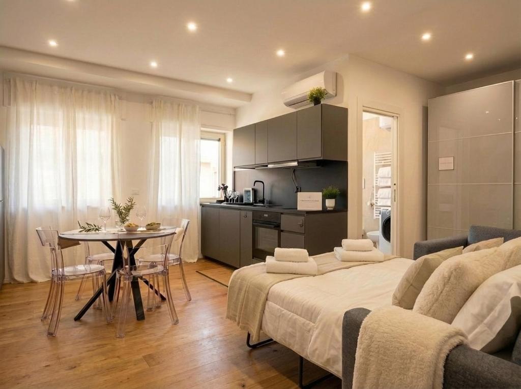 a room with two beds and a table and a kitchen at Sparano Mood 170 in Bari