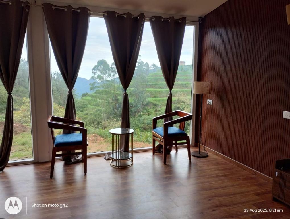 a room with two chairs and a large window at The Brookshore in Kodaikānāl